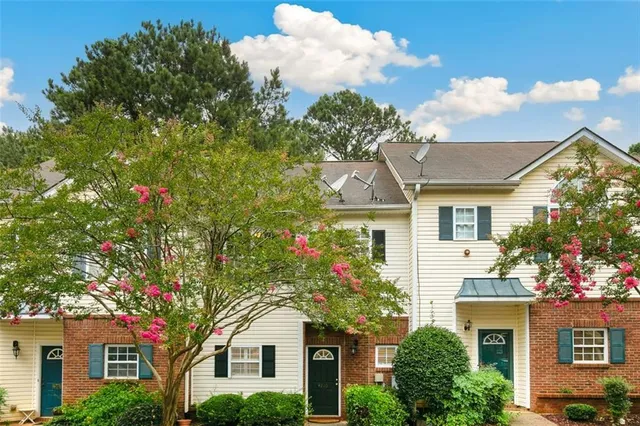 a front view of a house with a tree