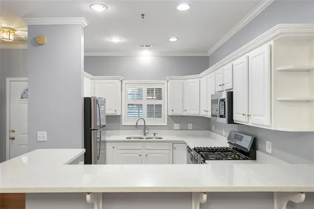 a kitchen with stainless steel appliances granite countertop a sink and a refrigerator
