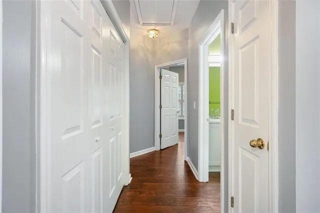 a view of a hallway with wooden floor and closet area