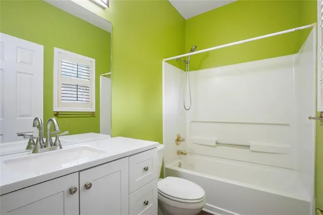 a bathroom with a granite countertop sink a toilet and shower