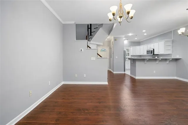 a view of a kitchen with a wooden floor and a ceiling fan