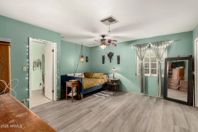a spacious bedroom with a bed and a chandelier