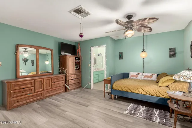 a bedroom with a bed chandelier and a window