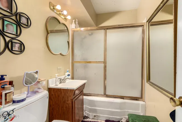 a bathroom with a sink mirror and a shower