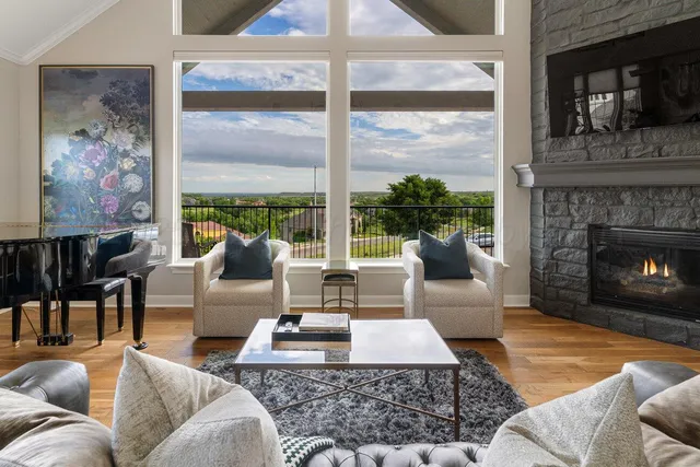 a dining room with wooden floor a chandelier a glass table and windows