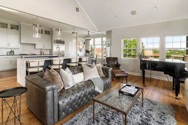 a dining room with wooden floor a chandelier a glass table and chairs