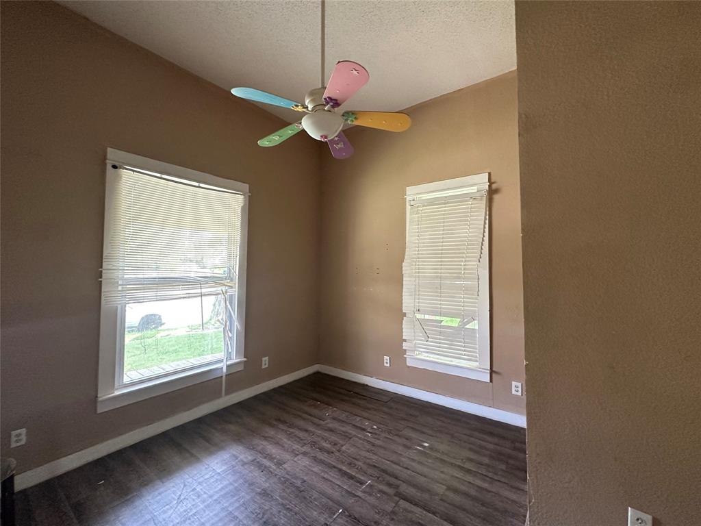 1405 Caddo Street Commerce, TX 75428 - Photo 4 of 8 a view of an empty room with wooden floor and a window