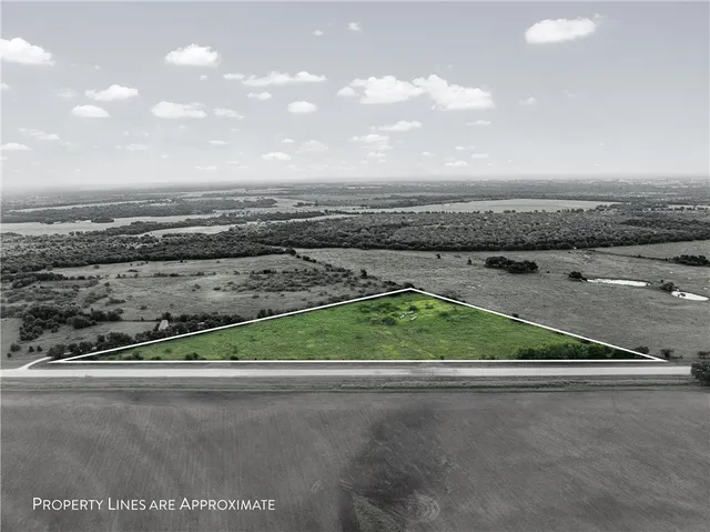a view of a field of grass and trees