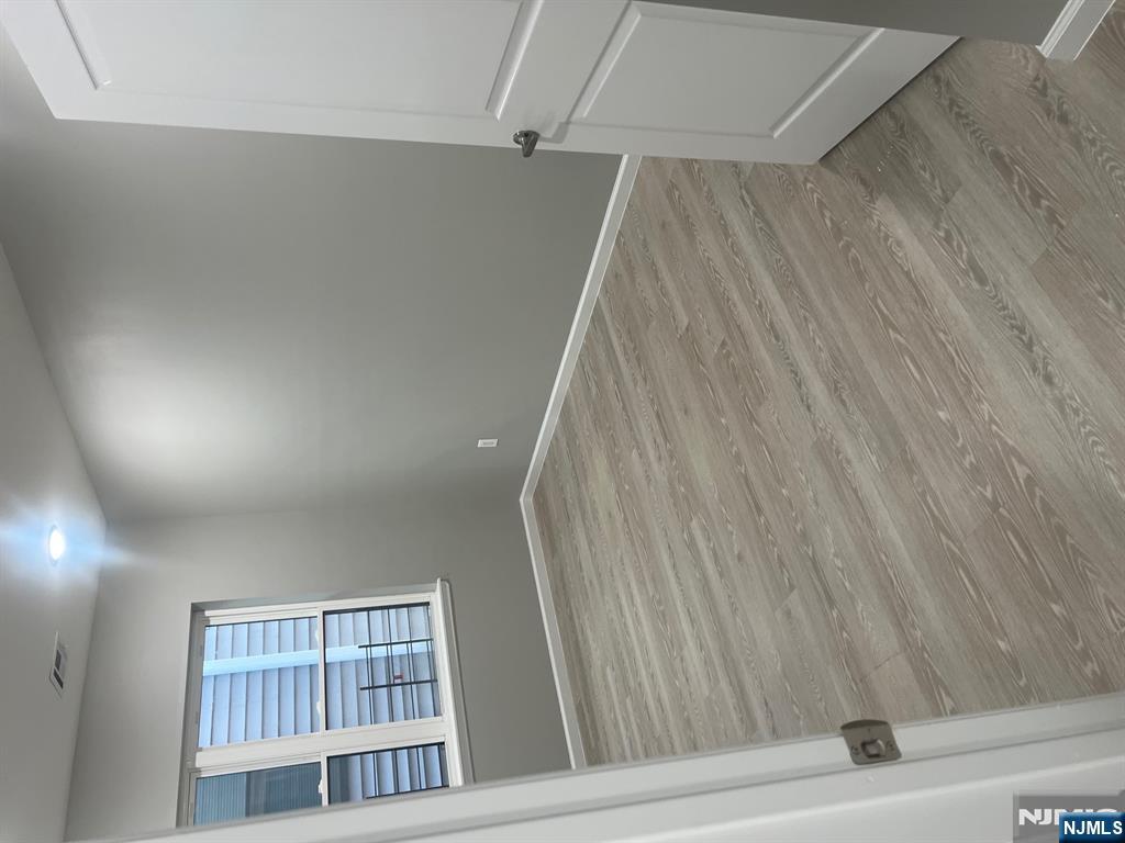 90-2 Montgomery Street, Unit 2 Paterson, NJ 07501 - Photo 2 of 9 an empty room with wooden floor and windows