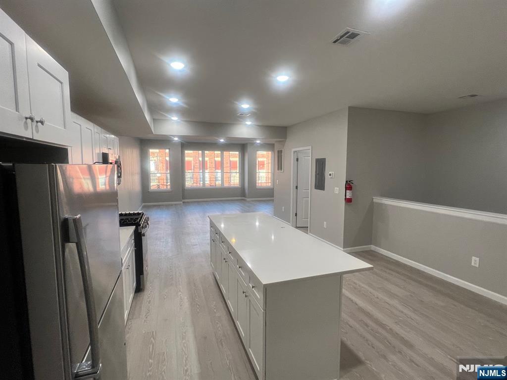 90-2 Montgomery Street, Unit 2 Paterson, NJ 07501 - Photo 5 of 9 a view of a refrigerator in kitchen and an empty room