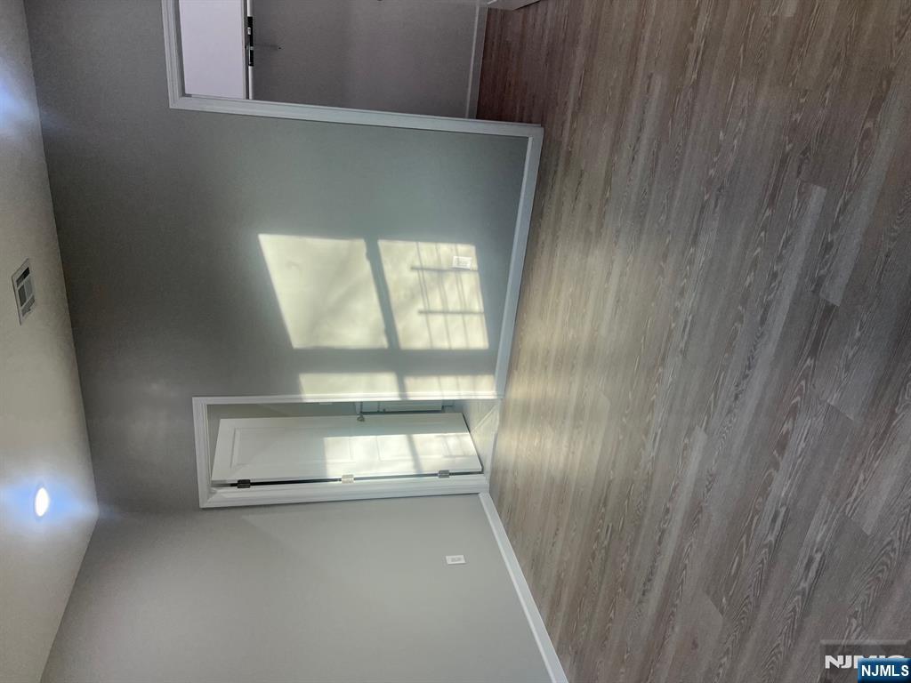 90-2 Montgomery Street, Unit 2 Paterson, NJ 07501 - Photo 6 of 9 a view of an empty room with wooden floor and a window