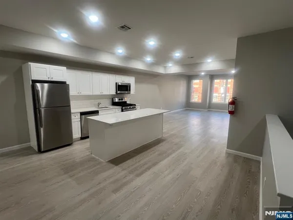 a large kitchen with a large window a refrigerator and a sink