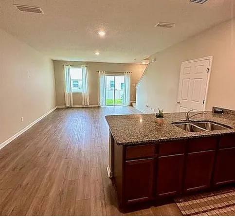 a view of a kitchen with granite countertop a sink dishwasher and wooden floor