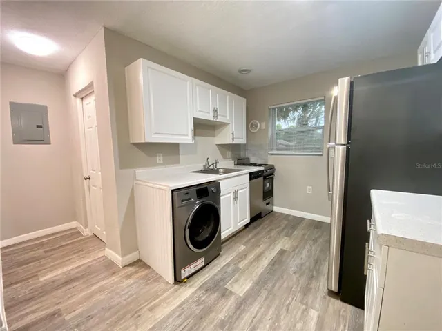 a kitchen with a sink a refrigerator and a stove