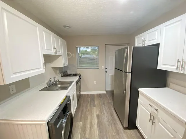 a kitchen with a refrigerator sink stove and cabinets