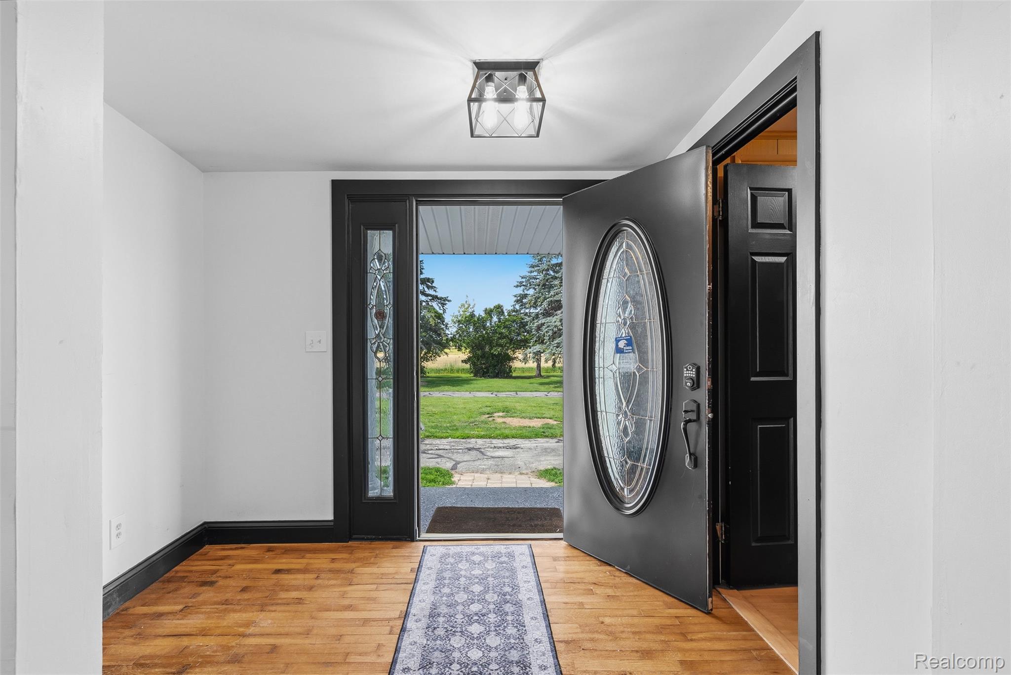 5843 West Dewey Road Owosso, MI 48867 - Photo 8 of 58 Entryway featuring wood-finish flooring, white walls, and dark trim