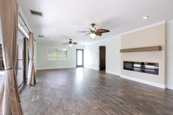an empty room with windows and fireplace