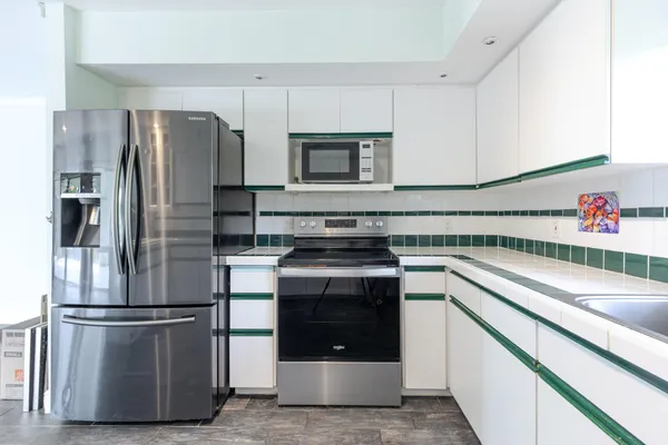 a kitchen with a stove refrigerator and microwave
