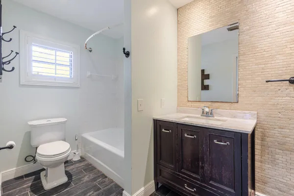 a bathroom with a granite countertop toilet sink and mirror