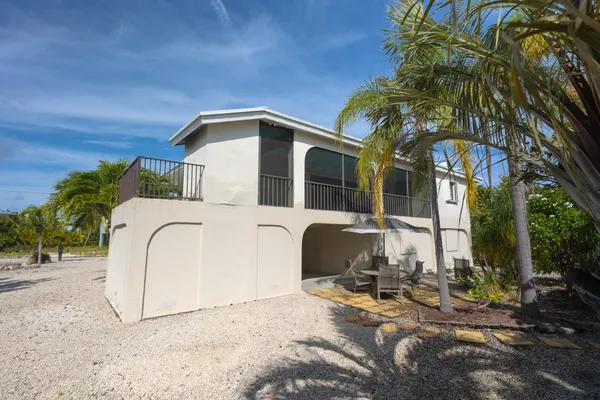 a view of a house with a small yard plants and palm trees