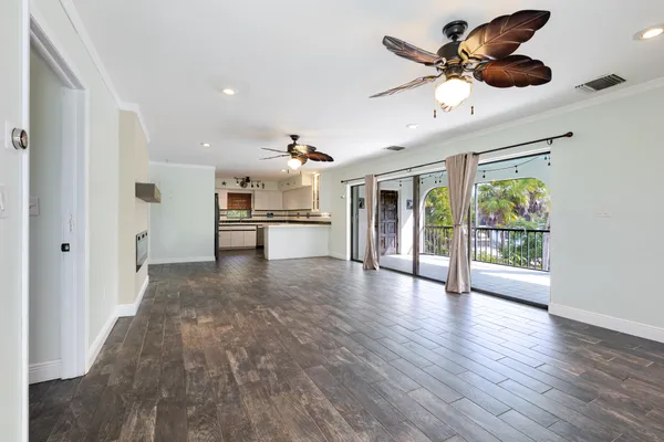 a view of a livingroom with a ceiling fan wooden floor and a ceiling fan