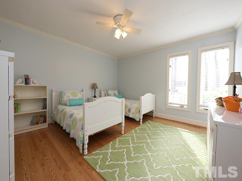 11908 Old Creedmoor Road Raleigh, NC 27613 - Photo 11 of 16 a bedroom with a bed and a chandelier