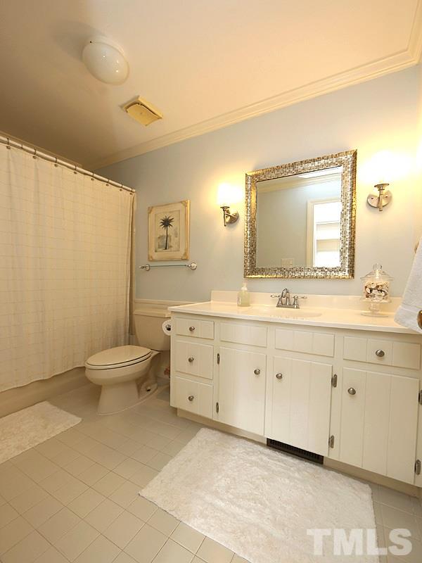 11908 Old Creedmoor Road Raleigh, NC 27613 - Photo 12 of 16 a spacious bathroom with a double vanity sink a mirror and a toilet