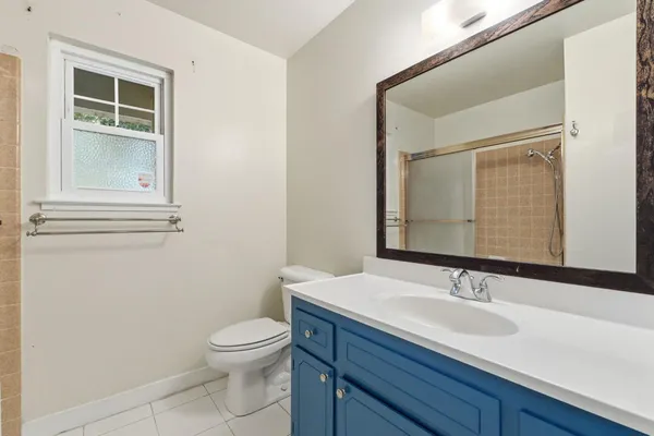 a bathroom with a toilet a sink and mirror