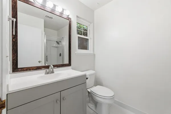 a bathroom with a sink a toilet and mirror