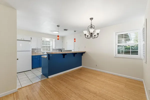 a kitchen that has a lot of cabinets in it with granite countertop wooden cabinets