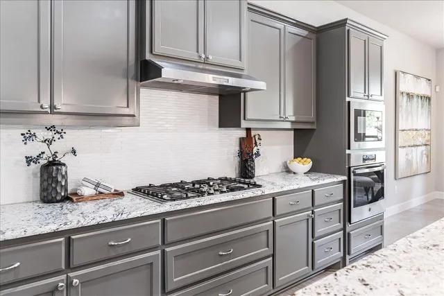 a kitchen with granite countertop a table chairs sink and cabinets