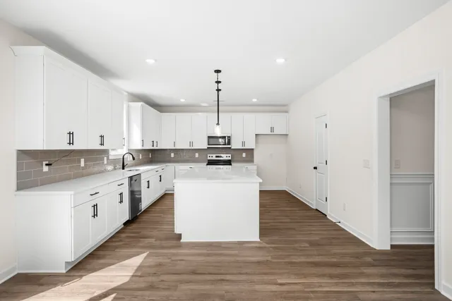 a kitchen with a sink stove and wooden floor