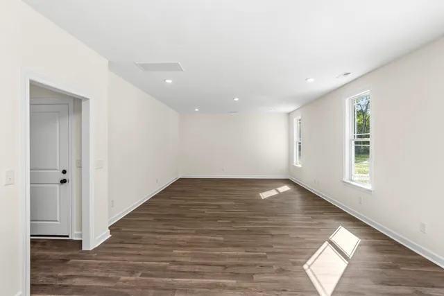 a view of a living room with kitchen furniture and wooden floor
