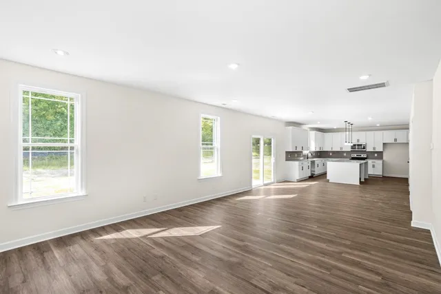 a view of a kitchen with wooden floor and windows