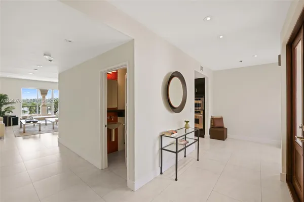 a spacious bedroom with a bed a table and large windows