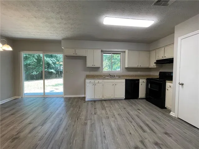 a kitchen with wooden floors and appliances