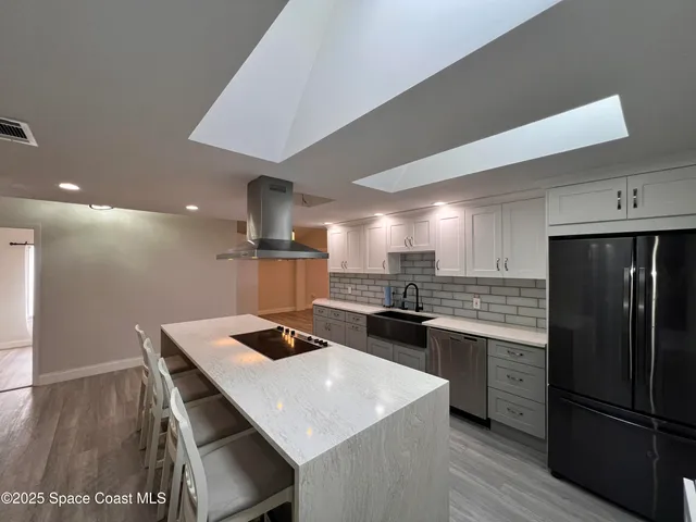 a kitchen with a appliances a refrigerator and a stove