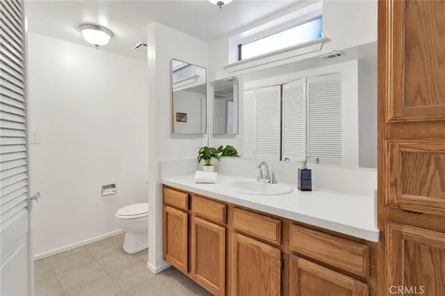 a bathroom with a toilet a sink and a large mirror