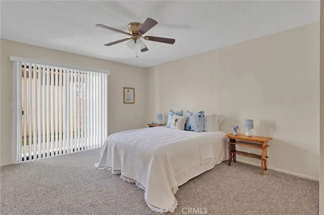 a bedroom with a bed and a ceiling fan