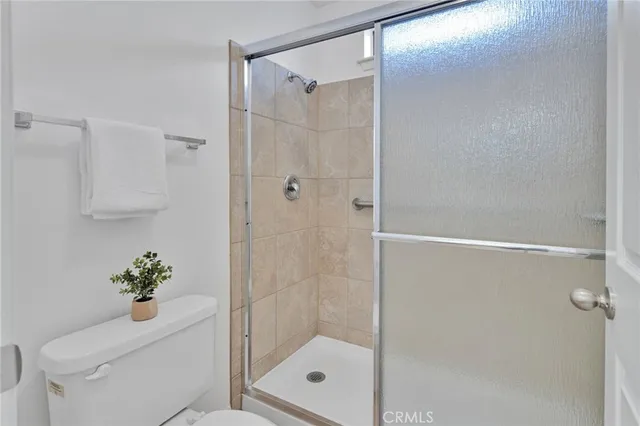 a bathroom with a shower a mirror a toilet and a shower