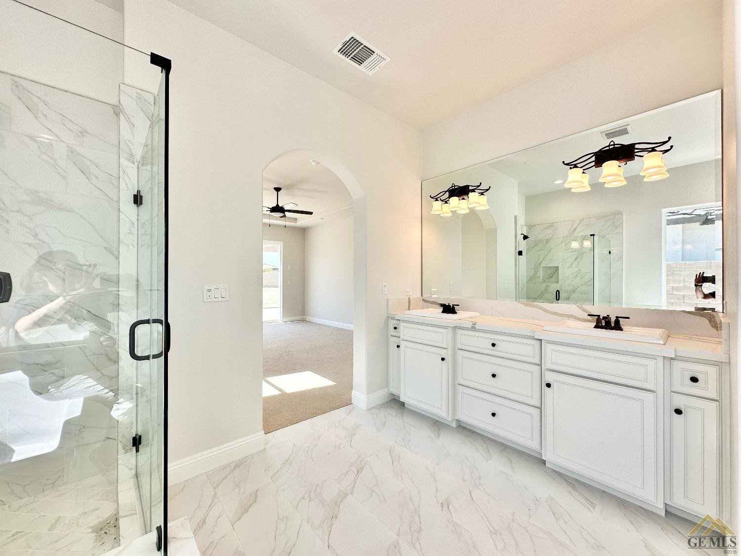 Undisclosed Address Bakersfield, CA 93314 - Photo 17 of 34 a spacious bathroom with a double vanity sink a large mirror a bathtub and