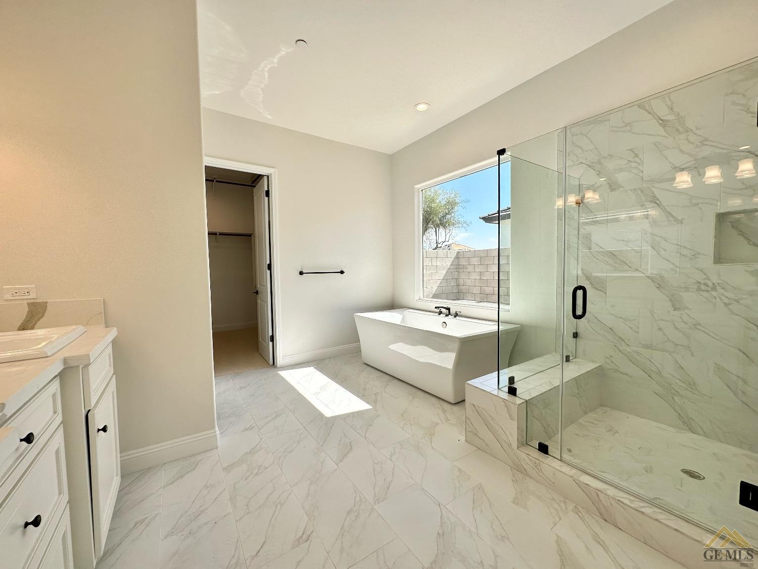 Undisclosed Address Bakersfield, CA 93314 - Photo 19 of 34 a spacious bathroom with a tub shower and mirror