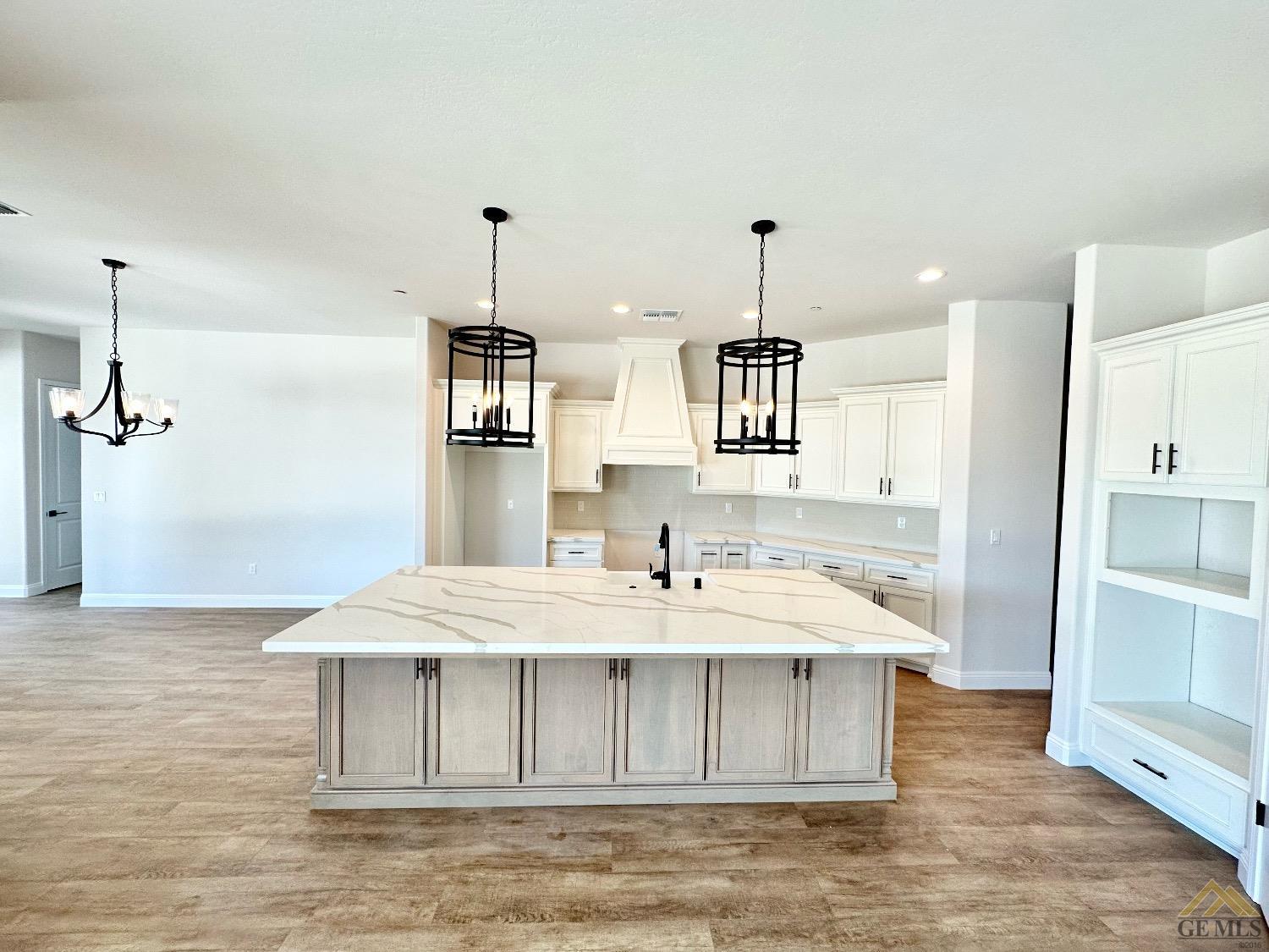 Undisclosed Address Bakersfield, CA 93314 - Photo 5 of 34 a kitchen with kitchen island a stove a sink and a refrigerator