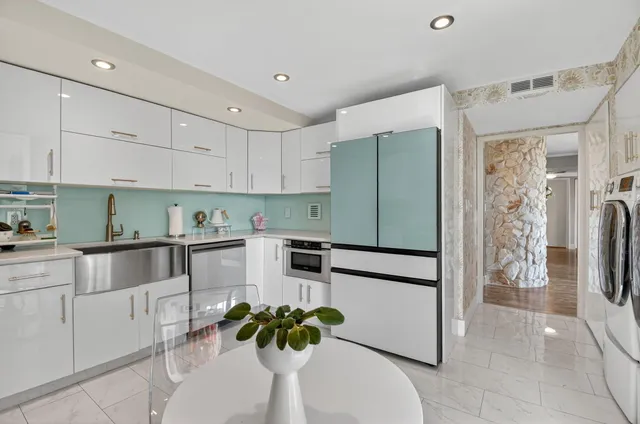 a kitchen with stainless steel appliances granite countertop a refrigerator and a stove top oven