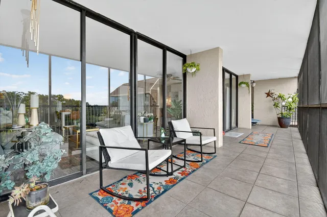 a view of a balcony with chair and potted plants
