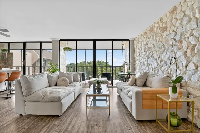 a living room with furniture and floor to ceiling windows