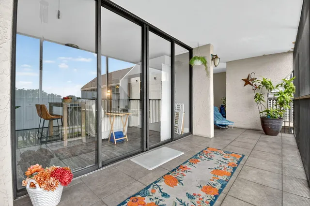 a view of a patio with table and chairs potted plants and a large tree