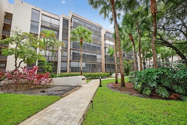 a living room with furniture a ceiling fan and a floor to ceiling window