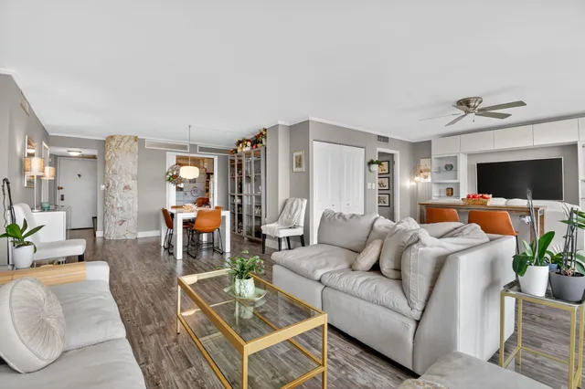 a very nice looking living room with a large window and wooden floor