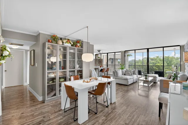 a living room with furniture and a large window with wooden floor